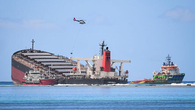 Dos pequeñas embarcaciones extraer el combustible restante del carguero. Foto: AFP.