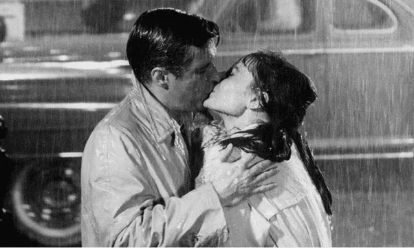 Beso entre Audrey Hepburn y George Peppard en Desayuno con diamantes. FOTO: Instagram / Rotten Tomatoes