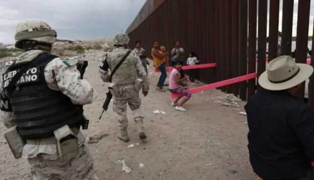 Militares mexicanos mientras observan divertirse a niños y adultos en el "sube y baja". (Foto: AP/Christian Chavez)