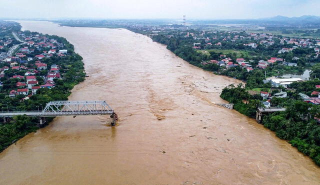 Un puente se derrumbó y un autobús fue arrastrado por las inundaciones. Foto: AFP.   