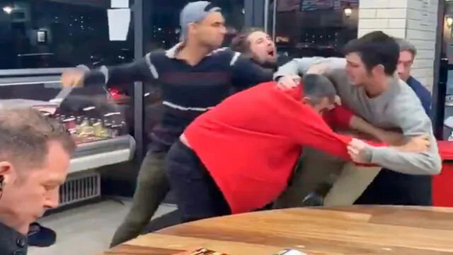 Un hombre imperturbable mira brutal pelea mientras come tranquilo sus papas fritas [VIDEO]
