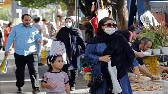 Iranians, some wearing face masks, walk at a market in the capital Tehran on June 3, 2020, amid the novel coronavirus pandemic crisis. - The spread of novel coronavirus has accelerated again this month in Iran which today officially confirmed over 3,000 new cases for a third consecutive day. (Photo by - / AFP)