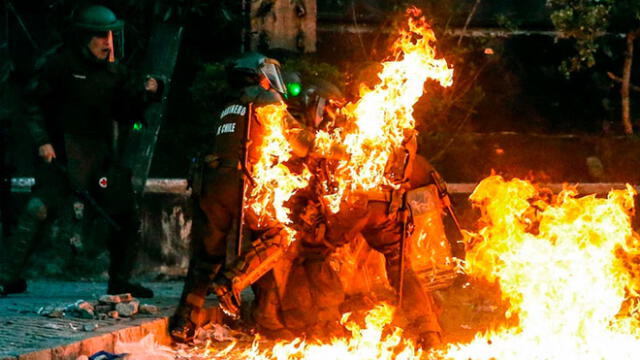 Un grupo de policías fue atacado con bombas molotov en medio de las protestas en Chile. Foto: AFP