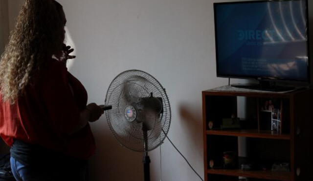 Una venezolana enciende su televisor sin señal de DirecTV. Foto: AFP.