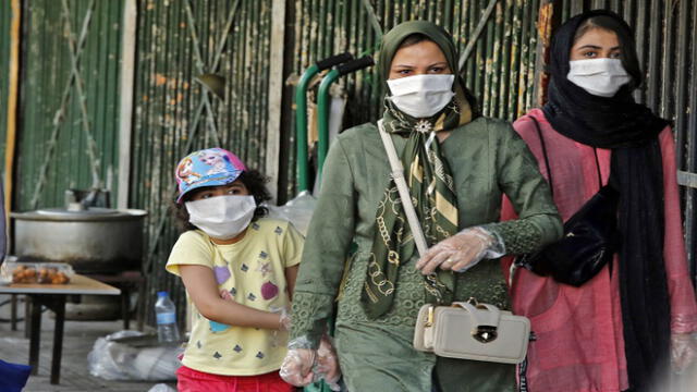Iranians wearing face masks walk along a street in the capital Tehran on June 3, 2020, amid the novel coronavirus pandemic crisis. - The spread of novel coronavirus has accelerated again this month in Iran which today officially confirmed over 3,000 new cases for a third consecutive day. (Photo by - / AFP)
