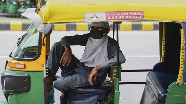 An auto rickshaw driver wearing a facemask as a preventive measure against the spread of the Covid-19 coronavirus, waits for passengers in New Delhi on August 30, 2020. - India on August 30 set a coronavirus record when it reported 78,761 new infections in 24 hours -- the world's highest single-day rise -- even as it continued to open up the economy. (Photo by Sajjad  HUSSAIN / AFP)