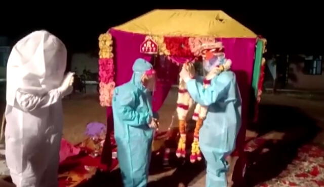 Pareja de India se casa con trajes especiales de protección para evitar contagiarse de COVID-19. Foto: captura video