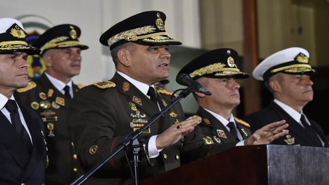 Venezuelan Defense Minister Vladimir Padrino Lopez (C) delivers a press conference in Caracas, along with members of the top military leadership "in support of the constitutional president", Nicolas Maduro on January 24, 2019. - Venezuelan leader Nicolas Maduro prepared to rally his military supporters Thursday as the US and key allies backed a challenge from his leading rival who declared himself "acting president." Padrino Lopez said the military would show "backing for the sovereignty" of Venezuela. (Photo by Luis ROBAYO / AFP)