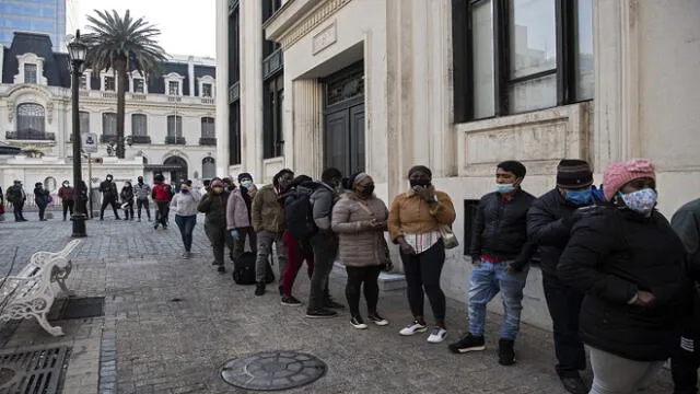 People wear face masks while queueing to enter a branch of the Pension Fund Administrators (AFP) office to start the procedure to withdraw up to a ten percent of their deposits in Santiago, on August 13, 2020. - The early withdrawal from pension funds in Chile, approved as an exceptional measure in the face of the economic crisis derived from the new coronavirus pandemic, "is starting to reactivate the economy", said Chilean Economy Minister Lucas Palacios Wednesday. (Photo by Martin BERNETTI / AFP)