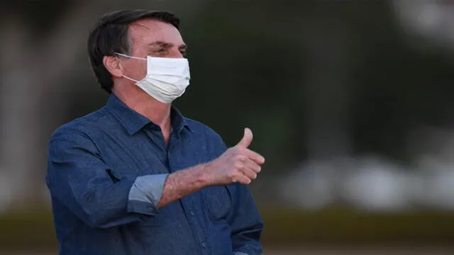 Brazilian President Jair Bolsonaro gives the thumb up while attending the flag unveiling ceremony at the Alvorada Palace in Brasilia, on July 15, 2020. - Brazil President Jair Bolsonaro tested positive for coronavirus again, CNN Brazil said on Wednesday, quoting the far right leader, who underwent a new test on Tuesday. (Photo by EVARISTO SA / AFP)