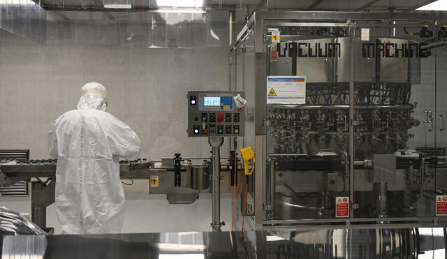 Un técnico de laboratorio participa en las pruebas de llenado y envasado a gran escala de la vacuna candidata de Oxford. Foto: AFP.