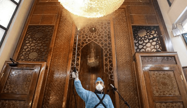 Trabajadores desinfectan una mezquita como parte de las medidas contra el coronavirus (COVID-19). Foto: AFP.