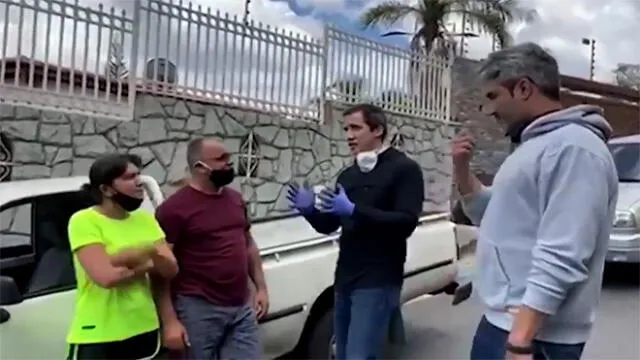 Grab taken from a handout video released by the National Communication Centre showing Venezuelan opposition leader Juan Guaido (2-R) speaking to people queueing for gas in a long line of vehicles in Caracas on June 6, 2020. - Venezuelan opposition leader Juan Guaido reappeared in the street in videos distributed on June 6, 2020 by his team and parliamentary allies, after foreign minister Jorge Arreaza claimed he had taken refuge in the French embassy in Caracas. (Photo by - / Centro de Comunicacion Nacional / AFP) / RESTRICTED TO EDITORIAL USE - MANDATORY CREDIT "AFP PHOTO / CENTRO DE COMUNICACION NACIONAL" - NO MARKETING - NO ADVERTISING CAMPAIGNS - DISTRIBUTED AS A SERVICE TO CLIENTS