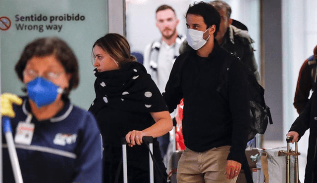 Pasajeros usan máscaras como precaución contra la propagación del nuevo coronavirus COVID-19 durante su llegada al Aeropuerto de Brasil. Foto:  EFE.