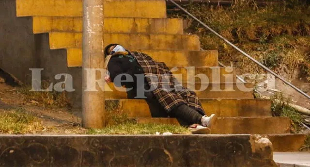 Una mujer duerme tendida en unas gradas, mientras espera atención médica. Créditos: Oswald Charca
