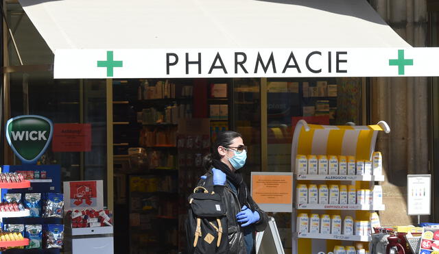 A man wearing a face mask leaves a pharmacy  in the city of Munich, southern Germany, on April 9, 2020 as public life in Bavaria has been limited due to the coronavirus COVID-19 pandemic. (Photo by Christof STACHE / AFP)