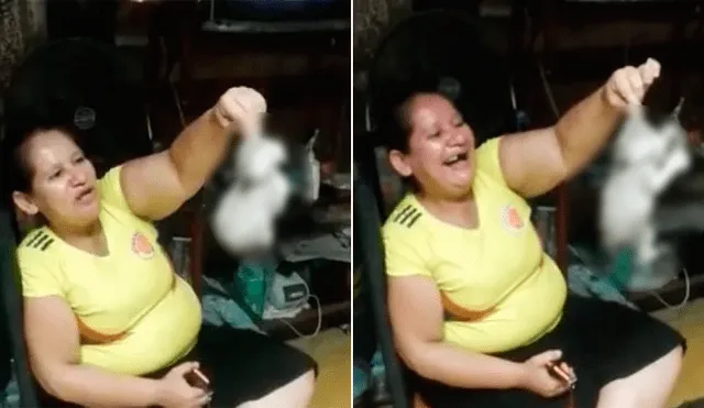 La mujer sostiene al gato bebé por su pequeña oreja, y al mismo tiempo, un hombre graba con su celular. Foto: Captura/Facebook