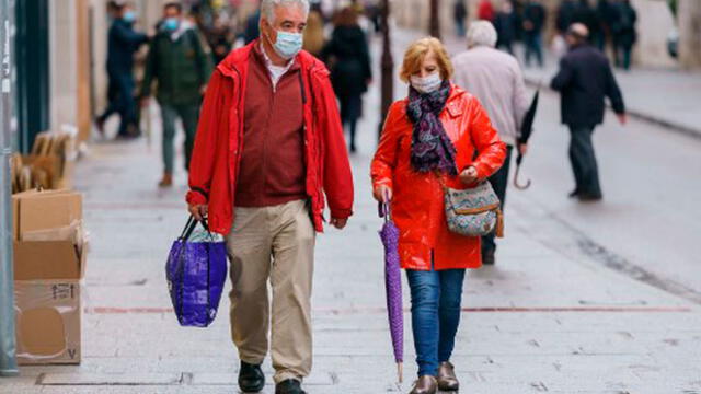 Dos personas caminan por las calles de Madrid protegidos con sus barbijos. Foto: AFP