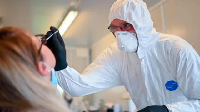Empleado de la salud en Alemania le toma una prueba a una mujer para descartar el coronavirus. Foto: AFP.
