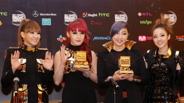 2NE1 en los MAMAs del 2011. Bom, de cabello rojizo, sostiene uno de sus premios.
