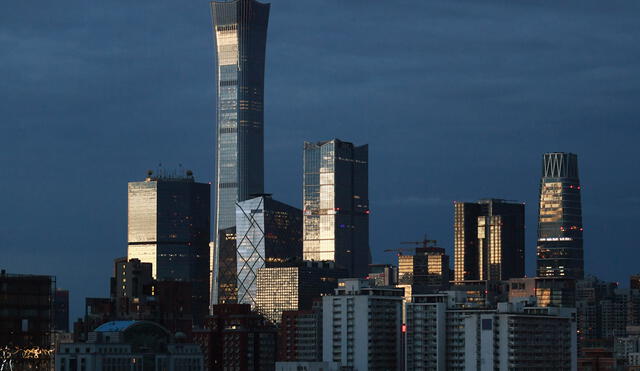 Light reflects off buildings in Beijing's central business district, including the city's tallest building, known as China Zun, at dawn on July 6, 2019. (Photo by GREG BAKER / AFP)