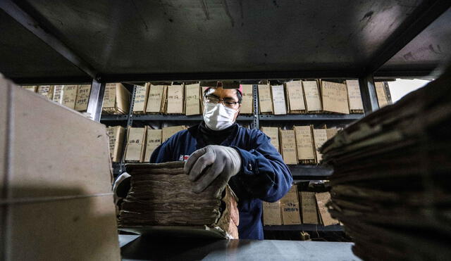 Trabajadores del Archivo Regional de Cusco manejan cuidadosamente los documentos.