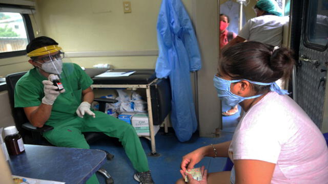 A doctor of Guayaquil's Mayoralty provides assistance to a resident of the Flor de Bastion housing cooperative, in Guayaquil, Ecuador, on May 9, 2020 during the COVID-19 novel coronavirus pandemic. - The novel coronavirus has killed at least 280,693 people worldwide since the outbreak first emerged in China last December, according to a tally from official sources compiled by AFP at 1900 GMT on Sunday. (Photo by Jose SANCHEZ / AFP)