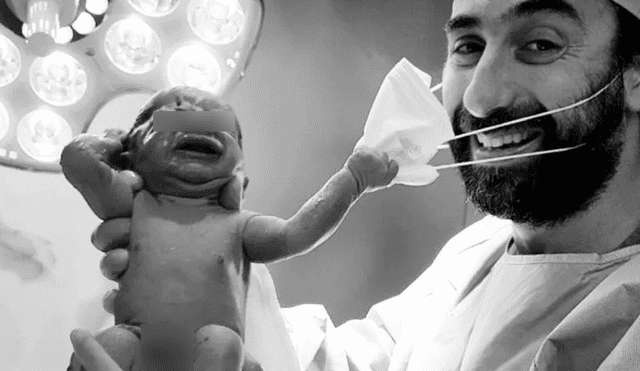 En la imagen se ve como un recién nacido intenta 'quitarle' el tapaboca al obstetra. Foto: Instagram