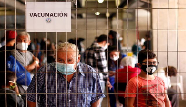 Un anciano y un niño son vistos el sábado en la jornada de vacunación contra la influenza en la Florida en Santiago (Chile). Foto: EFE