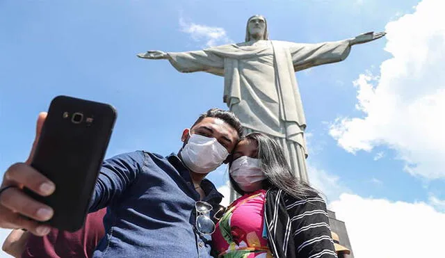 Con mascarillas los turistas siguen visitando el monumento del Cristo Redentor. Foto: EFE