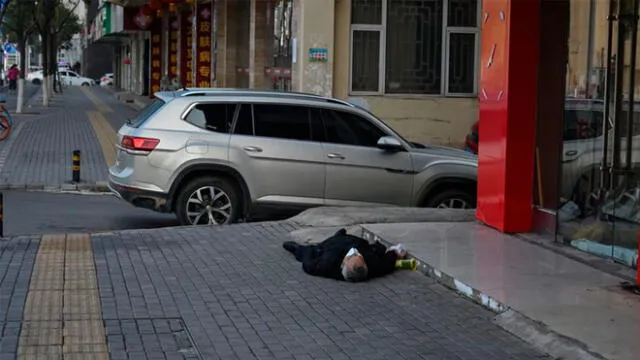 Un hombre sin vida permaneció tirado durante varias horas en plena calle de Wuhan. Foto: AFP