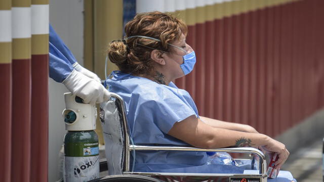 A health worker pushes a woman on a wheelchair at the triage area of the General Hospital in Mexico City on May 10, 2020, amid the new Covid-19 coronavirus pandemic. (Photo by PEDRO PARDO / AFP)