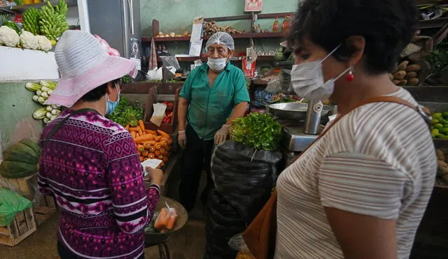 Shoppers wear face masks to prevent the spread of the new coronavirus at a neighborhood market in Lima, on April 2, 2020. - Peru reinforced on Thursday the circulation restrictions to control the coronavirus spread by prohibiting men and women from going out together, each gender will have to alternate their daily outing as part of the strategy to avoid contagion. (Photo by Cris BOURONCLE / AFP)
