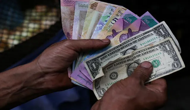 A market trader shows different currency notes in Caracas on March 10, 2019, during the third day of a massive power outage which has left Venezuelans without communications, electricity and water. - The unprecedented power outage already left 15 patients dead and threatens to extend indefinitely, increasing distress for the severe political and economic crisis hitting the oil-rich South American nation. (Photo by Cristian Hernandez / AFP)