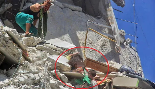 An image grab taken from a video by Syrian news website SY24 on July 24, 2019 shows a Syrian man reacting as two dust-covered Syrian girls, trapped in rubble, grab their baby sister from her shirt as she dangles from a bombed-out building in the Syrian town of Ariha in the northwestern province of Idlib. - Of the three girls shown in the photo, one is dead and two are fighting to stay alive, after regime airstrikes hit their home, said Dr Ismail, who treated the victims in a nearby hospital. Riham, 5, who appears in the photo gripping her sister's green shirt, died on Wednesday, the doctor said. Touka, the seven-months-old girl who is shown dangling in the air, is currently in intensive care, after suffering a trauma to the head, he added. Dalia, who also appears in the photograph, is stable after undergoing chest surgery, according to Mohamed, another doctor at the same facility. The girls are part of a family of eight, consisting of two parents and six sisters. (Photo by Bashar al-Sheikh / SY24 / AFP) / ===RESTRICTED TO EDITORIAL USE - MANDATORY CREDIT "AFP PHOTO / HO / SY24"- NO MARKETING NO ADVERTISING CAMPAIGNS - DISTRIBUTED AS A SERVICE TO CLIENTS FROM FROM ALTERNATIVE SOURCES, THEREFORE AFP IS NOT RESPONSIBLE FOR ANY DIGITAL ALTERATIONS TO THE PICTURE'S EDITORIAL CONTENT, DATE AND LOCATION WHICH CANNOT BE INDEPENDENTLY VERIFIED == /