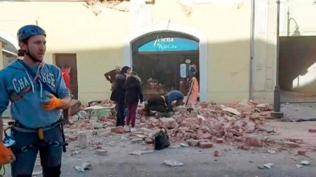Una captura de un video tomado y publicado por la Cruz Roja Croata el 29 de diciembre de 2020 muestra a personas mirando a través de los escombros y rescatando víctimas en las calles. Foto: AFP
