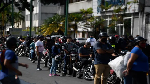 Bikers wait in a queue to refuel their tanks at a gas station, in Caracas on June 1, 2020 amid the novel COVID-19 coronavirus outbreak. - Venezuela will increase fuel prices in June, President Nicolas Maduro said on Saturday, putting a limit on state subsidies that for decades had allowed citizens to fill their gas tanks virtually for free. (Photo by Federico PARRA / AFP)