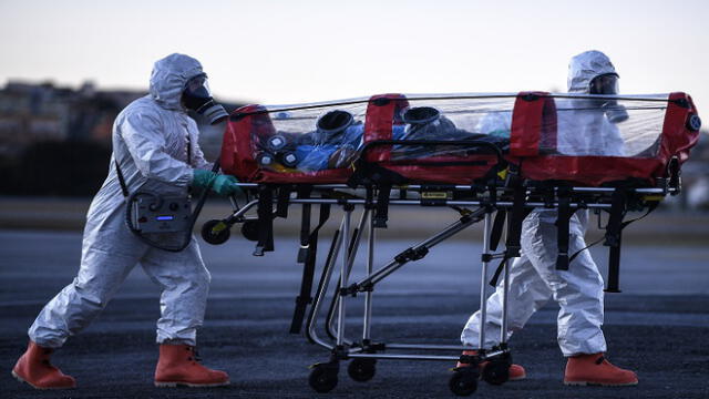 Members of the Military Firefighter Brigade of Minas Gerais (CBMMG) wearing protective gear, demonstrate the use of an isolation stretcher, or  bubble stretcher, to transport patients infected with coronavirus (COVID-19), at Pampulha Airport, in Belo Horizonte, state of Minas Gerais, Brazil, on July 22, 2020. - The equipment, which can be used to transport patients in aircrafts and ambulances, filters the air that the patient exhales in addition to isolating him. (Photo by DOUGLAS MAGNO / AFP)