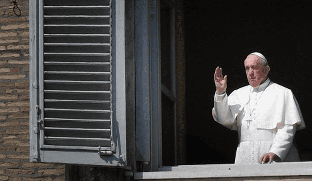 Papa Francisco saluda desde la ventana del palacio apostólico con vista a una plaza vacía de San Pedro después de su transmisión en vivo de la oración del Ángelus. Foto: AFP.