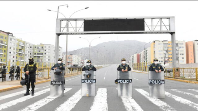 Policías resguardan calle para hacer cumplir restricciones. (Foto: Andina)