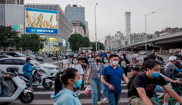 Gente con mascarilla camina por la calle en Pekín, China. Foto: EFE