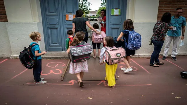 Parents and children arrive at the Jules Julien elementary school in Toulouse, southern France, on June 22, 2020 following the reopening of schools as France eases lockdown measures taken to curb the spread of the COVID-19 (the novel coronavirus). (Photo by Lionel BONAVENTURE / AFP)
