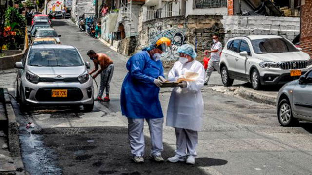Los trabajadores de la salud son fotografiados durante una prueba aleatoria en el barrio de Santa Cruz en Medellín. Foto: AFP.