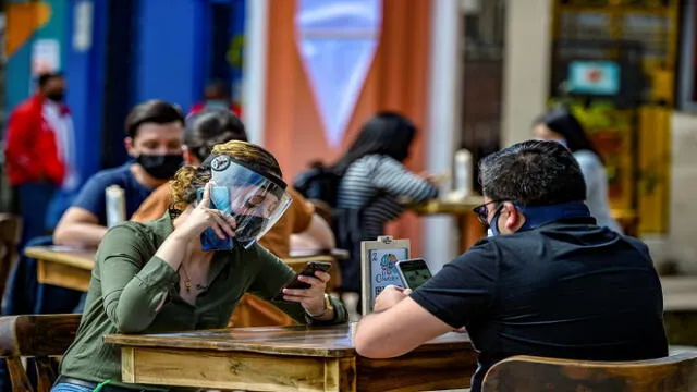 People wear face masks and shields during a pilot test of restaurant opening in Chorro de Quevedo tourist area, in Bogota on September 1, 2020, during te coronavirus pandemic. - Bogota, the focus of the pandemic in Colombia, left behind its strict quarantine by zones and began to ease restrictive measures against the new coronavirus, mainly aimed at relaunching the declining trade in the capital. (Photo by Juan BARRETO / AFP)