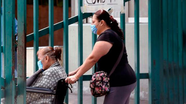 Una mujer lleva a otra en una silla de ruedas hacia un hospital en México en medio de la pandemia del coronavirus. Foto: AFP.