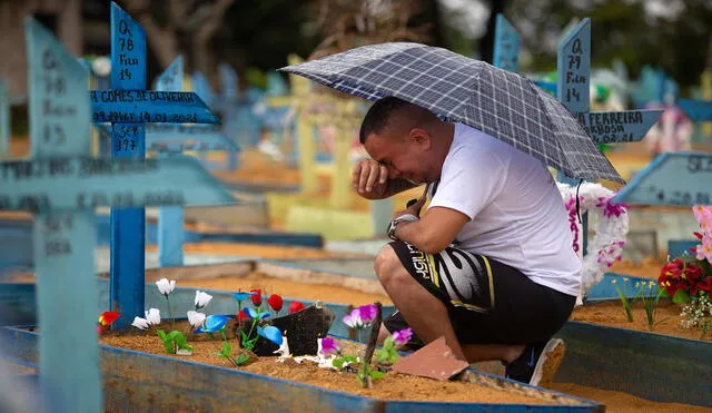 A man cries by a grave at the Nossa Senhora Aparecida cemetery on Mothers Day, in Manaus, Amazonas State, Brazil, on May 9, 2021, amid the COVID-19 novel coronavirus pandemic. - Cemeteries in Brazil opened this weekend for the first time for the general public since the start of the COVID-19 pandemic. (Photo by Michael DANTAS / AFP)