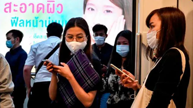 Pasajeros con máscaras faciales en medio de la propagación del nuevo coronavirus abordan un tren de cercanías. Foto: AFP.