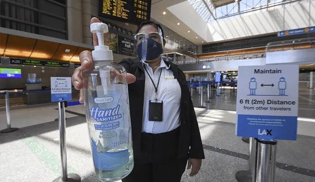 La empleada del aeropuerto internacional de Los Ángeles, Gigi Bebikian, con una botella de desinfectante de manos. | Foto: Robyn Beck / AFP