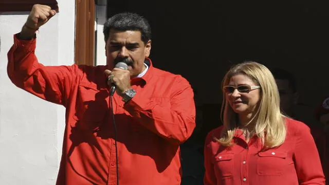Venezuelan President Nicolas Maduro (L), flanked by his wife Cilia Flores, speaks from a balcony at the Miraflores Palace to a crowd of supporters during the International Anti-imperialist March in Caracas, on January 23, 2020. - The march takes place in the framework of the Sao Paulo Forum meetings, being held in Caracas until Friday. (Photo by YURI CORTEZ / AFP)