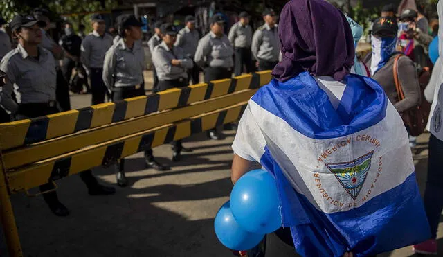 AME4765. MANAGUA (NICARAGUA), 19/06/2019.- Una mujer con la bandera de Nicaragua sobre su espalda participa en un plantón este miércoles, en las afueras de la cárcel "La Modelo", en Managua (Nicaragua). Un grupo de opositores realizó este miércoles una protesta en Nicaragua para exigir la liberación de cerca de un centenar de "presos políticos", que no son reconocidos por el Gobierno del presidente Daniel Ortega. Miembros del Comité Pro Liberación de Presas y Presos Políticos, la Unión de Presos Políticos Nicaragüense, y la Alianza Cívica por la Justicia y la Democracia, realizaron un plantón en las afueras de la cárcel "La Modelo" para hacer notar su descontento con la decisión del Gobierno de no liberar a más de 80 manifestantes encarcelados. EFE/ Jorge Torres